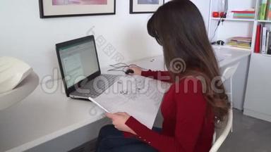 设计工程师坐在她办公室的<strong>办公桌</strong>前，在笔记本电脑上打字，在她的<strong>办公桌</strong>上放蓝图